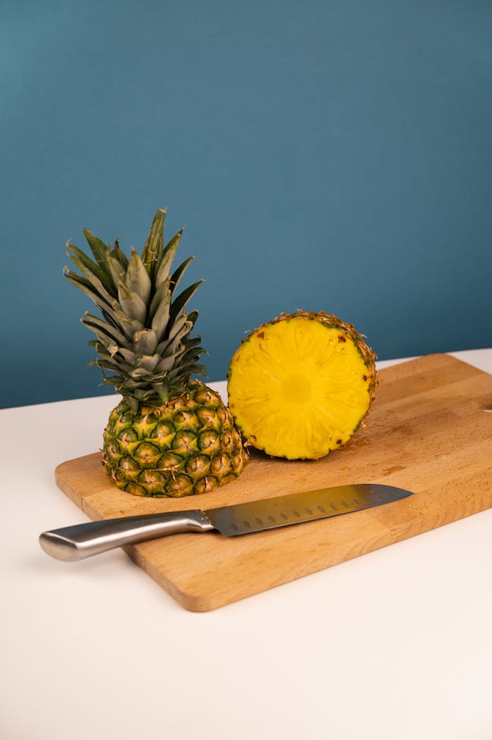 Sliced pineapple on a cutting board with knife, vibrant and healthy tropical fruit.
